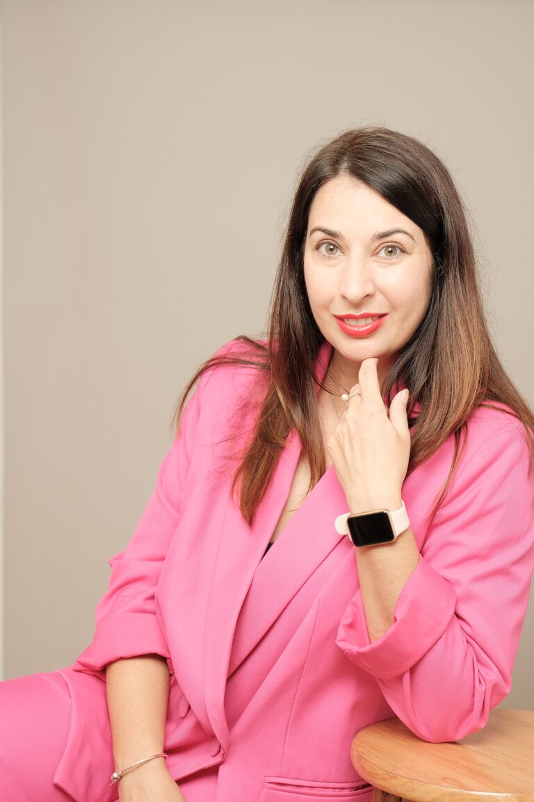 Kalina, founder of Promptive, smiling in a pink blazer